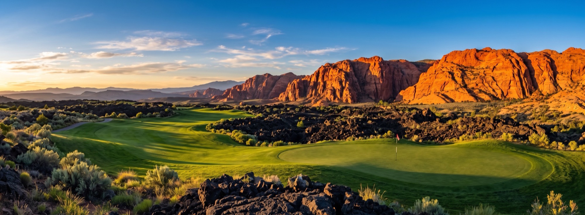 Panoramic view of an emerald fairway winding through black lava fields